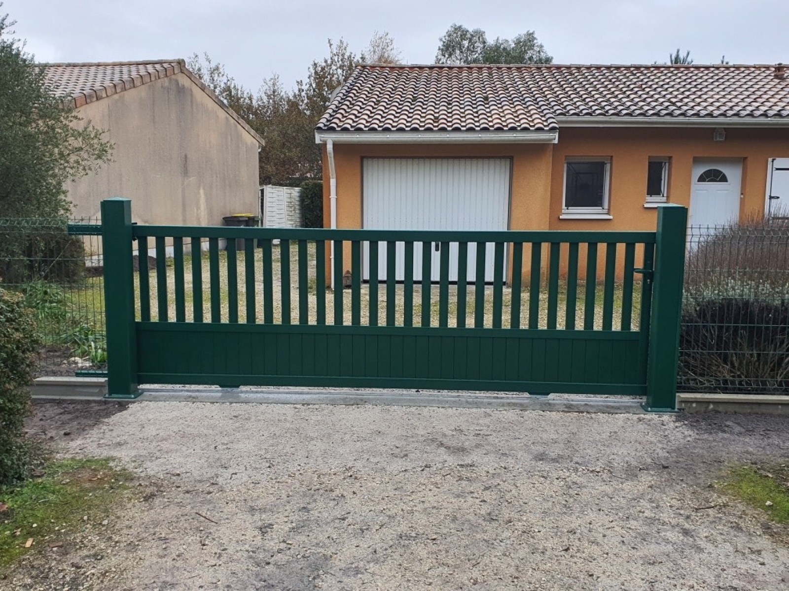 Remplacement d’un portail vétuste par un portail coulissant en aluminium RAL 6005 Vert barreaudé à soubassement plein avec une clôture rigide à Hourtin (33) !
