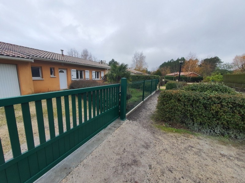 Remplacement d’un portail vétuste par un portail coulissant en aluminium RAL 6005 Vert barreaudé à soubassement plein avec une clôture rigide à Hourtin (33) !